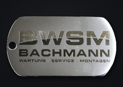 Dogtag aus Edelstahl mit laserbeschriftetem Logo BWSM Bachmann und dem Zusatz Wartung, Service, Montagen